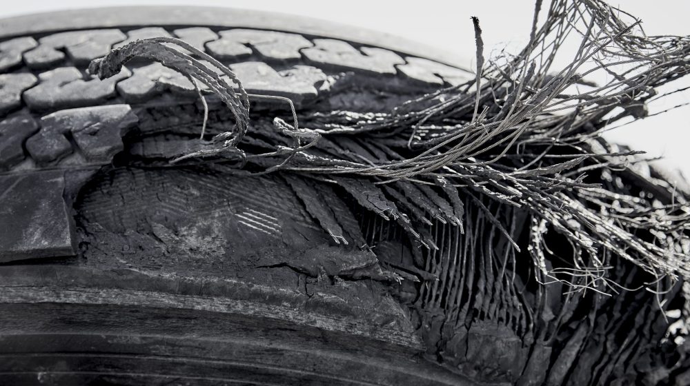 Old tire with layers exposed showing the steel and fibre remnants that are used in tire construction