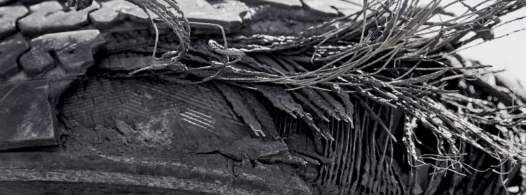 Old tire with layers exposed showing the steel and fibre remnants that are used in tire construction